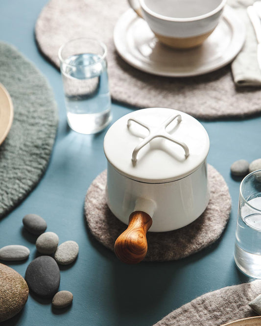 Farmhouse pottery artisan felt hot pad with white pot.