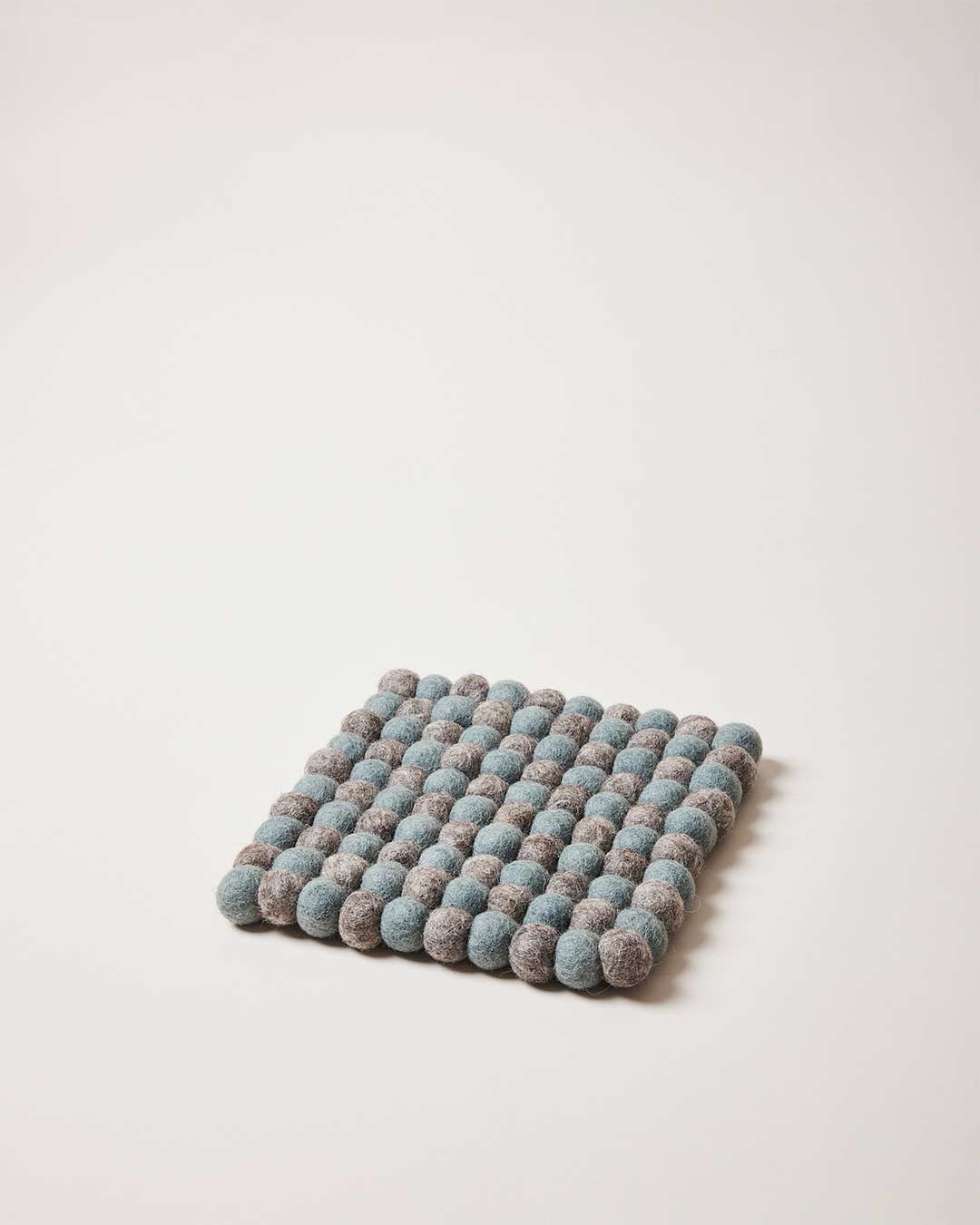 Farmhouse Pottery artisan felt pom pom trivet teal and pebble grey.