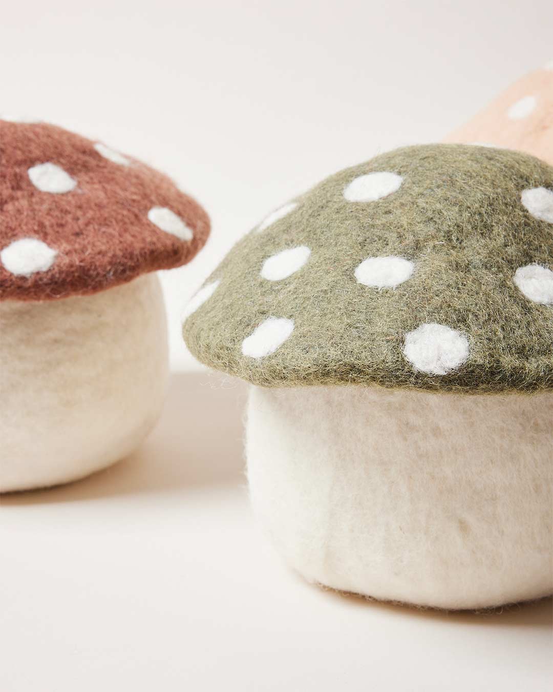 Farmhouse Pottery artisan felted mushroom doorstops in three colors. 