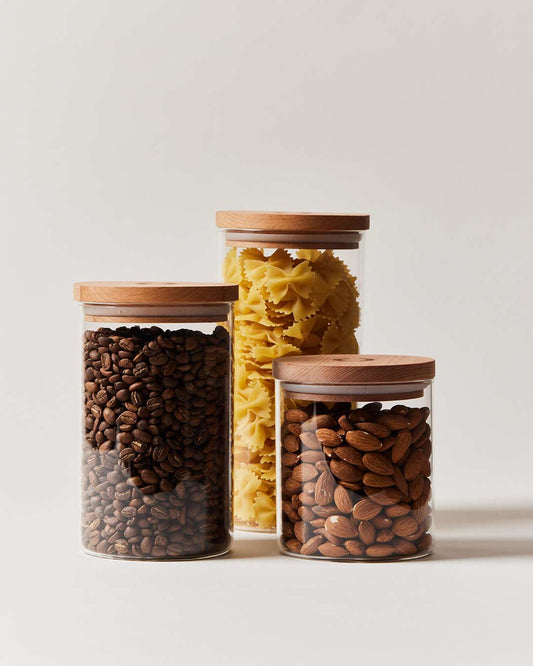Farmhouse Pottery glass utility cannisters in small medium and large filled with coffee beans almonds and pasta.