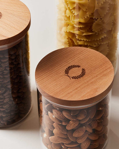 Farmhouse pottery glass utility canisters detailed photo of wooden lid with engraved laurel design.
