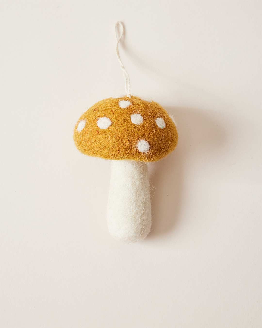 Farmhouse Pottery felted mushroom ornament in ochre. 