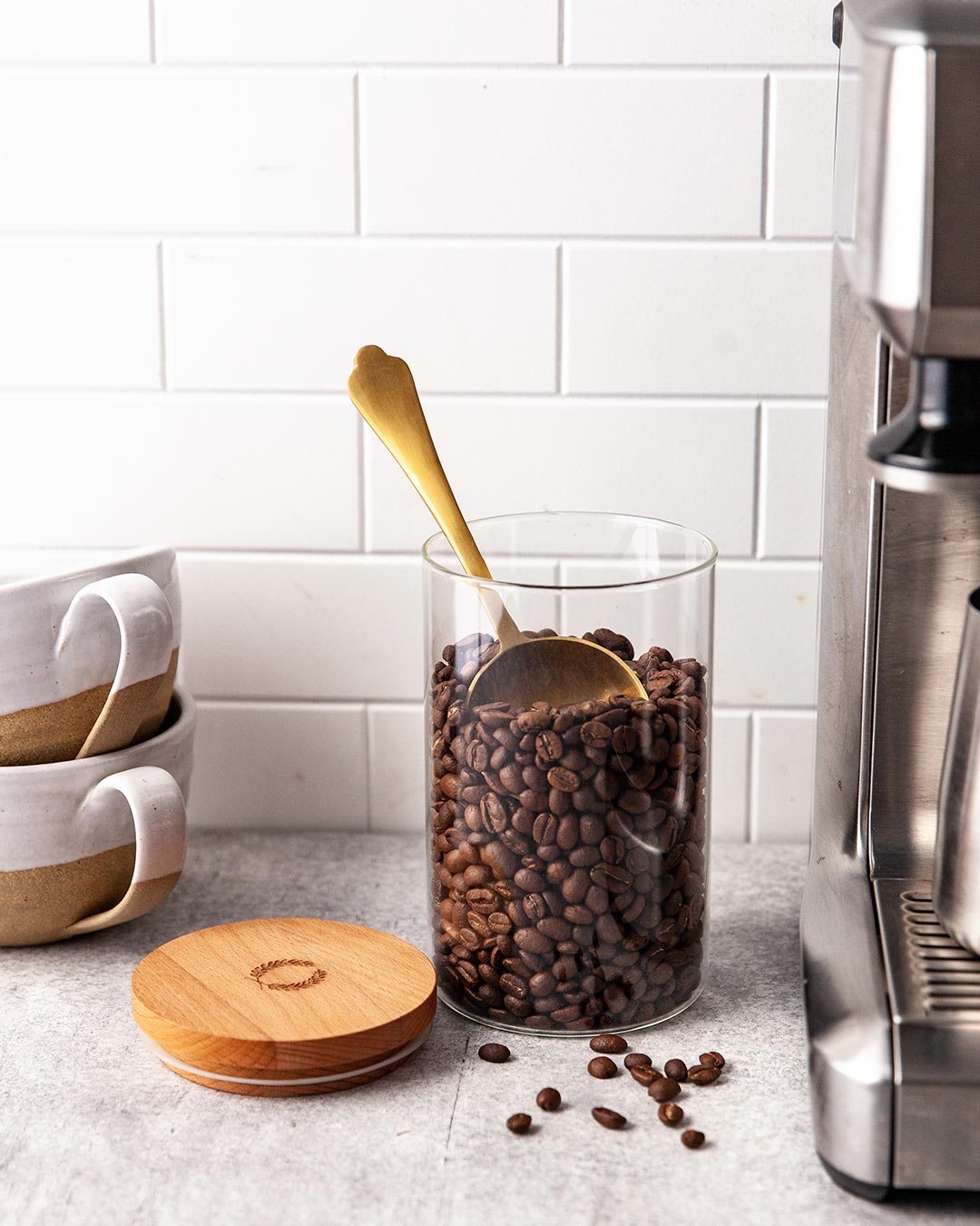 Farmhouse pottery glass utility canister filled with coffee beans.