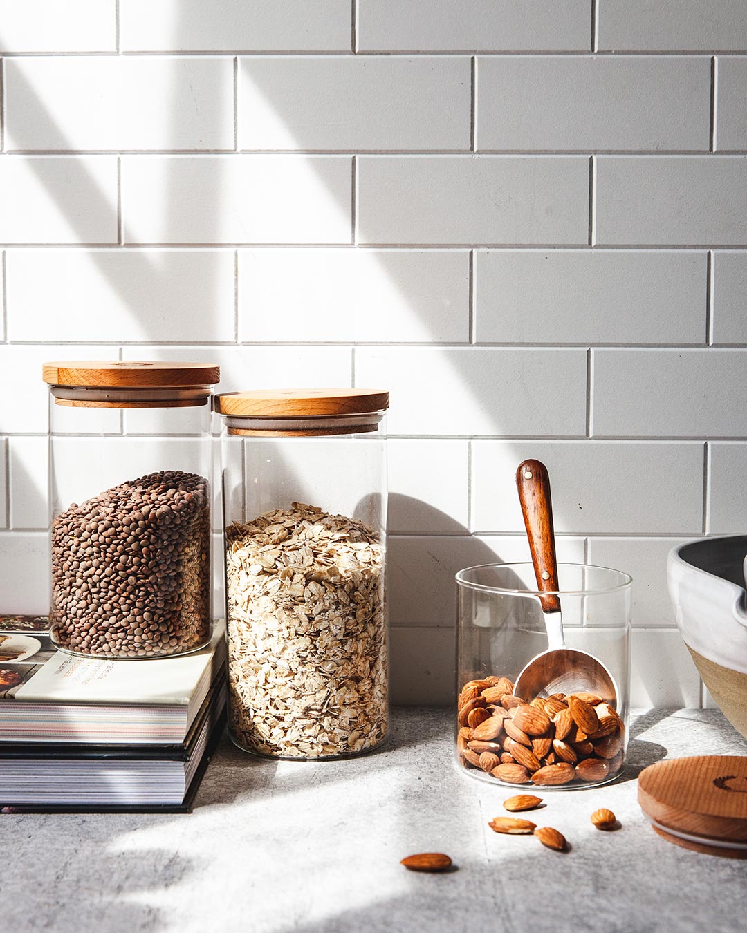 Farmhouse Pottery glass utility canisters on kitchen counter.