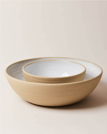 Farmhouse Pottery Harvest Serving Bowls stacked with a light cream background. Each bowl has an exposed clay outside and a milky white glaze interior.