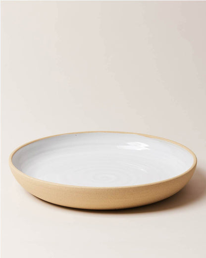 Farmhouse Pottery Harvest Serving platter with a light cream background. The platter has an exposed clay outside and a milky white glaze interior.