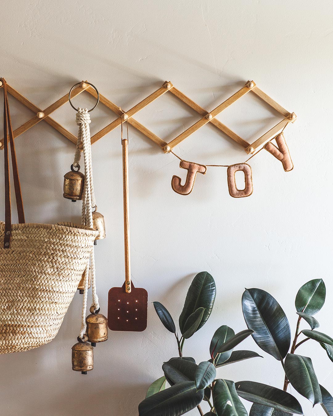 Farmhouse Pottery holiday greeting joy in blush velvet hanging from coat rack.