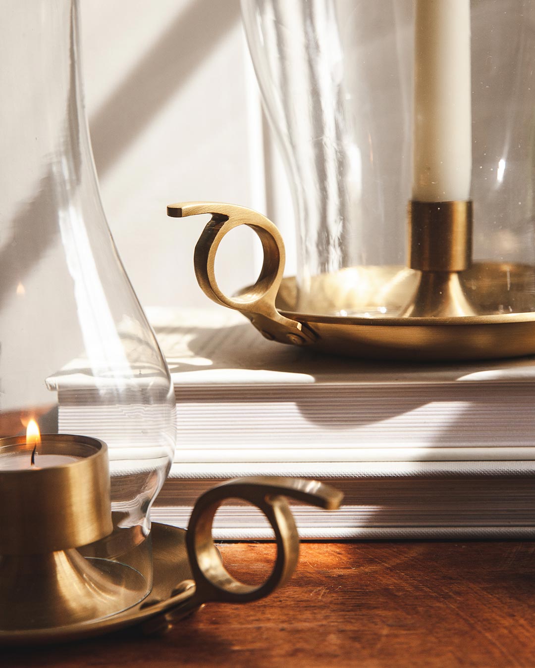 Close up shot of handles on farmhouse pottery windsor hurricane and windsor lantern sitting on table.